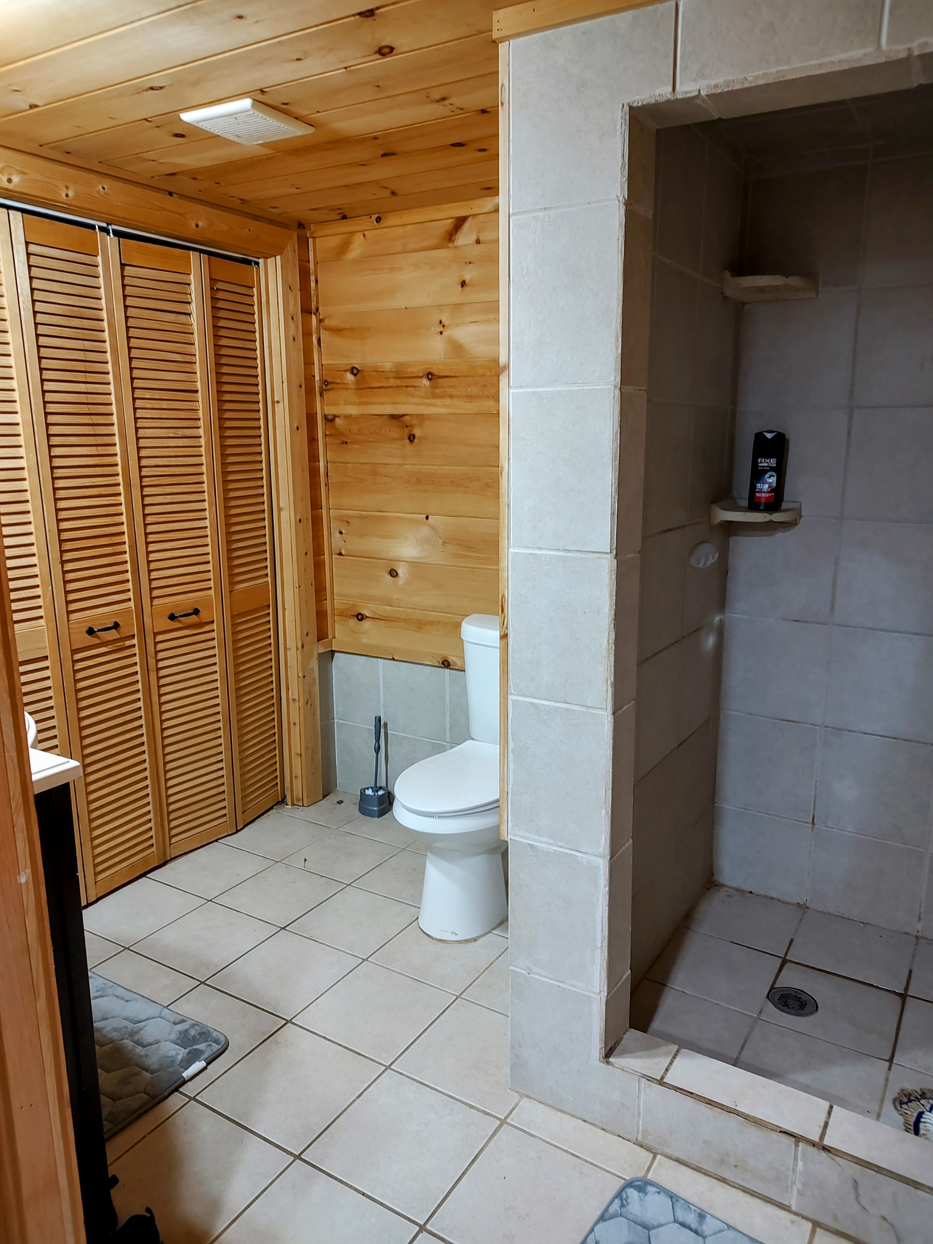 Guest bathroom and laundry with tile shower and pine walls